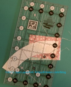 Place ruler on sewn line